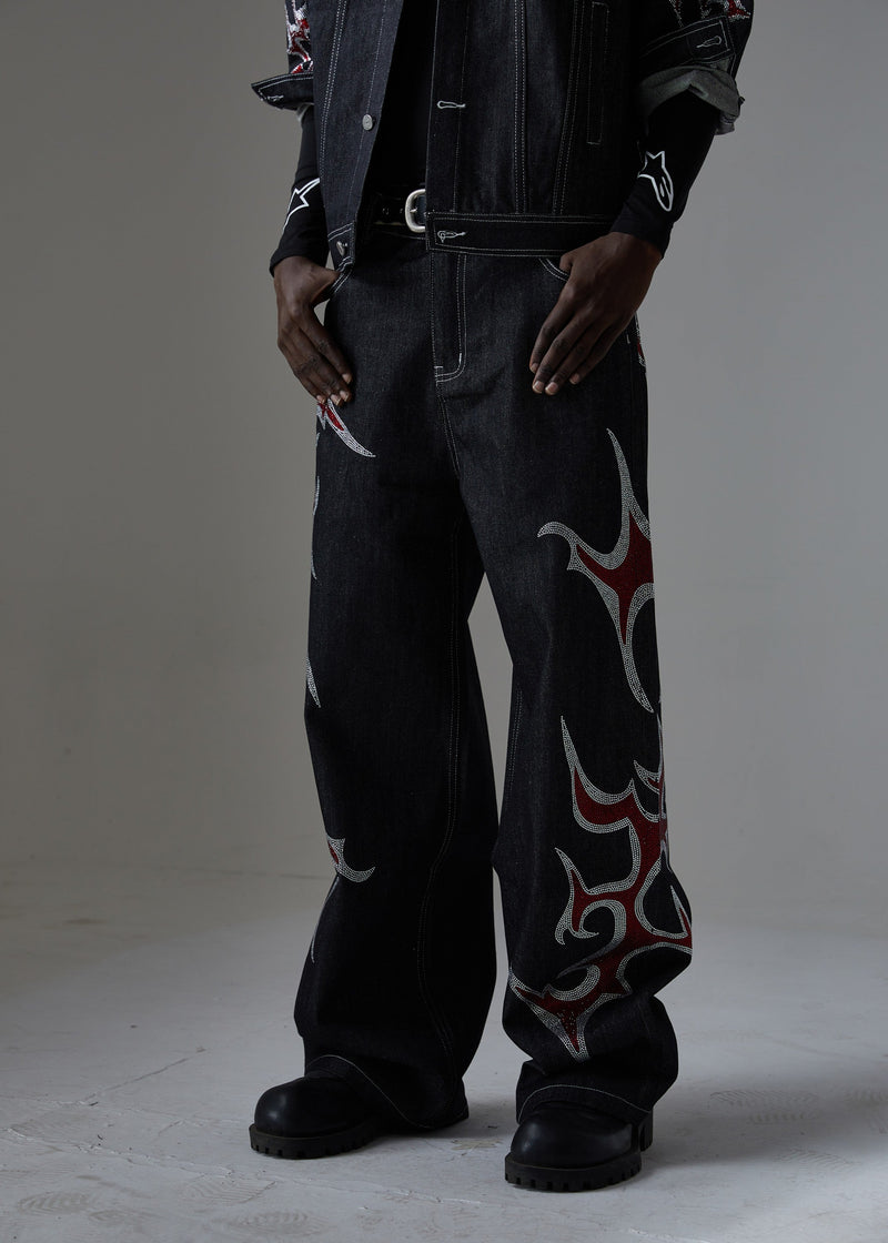 Front view of black wide-leg denim pants with red and silver rhinestone flame graphics