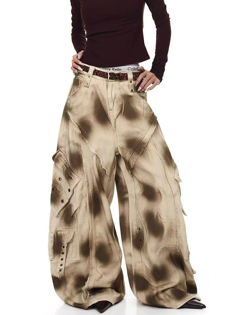Model wearing distressed cargo barrel pants in a front three-quarter view with wide legs and snap pockets