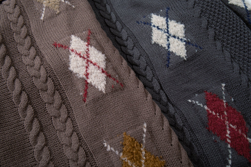Close-up of brown and dark charcoal cardigan sleeves with argyle knit pattern