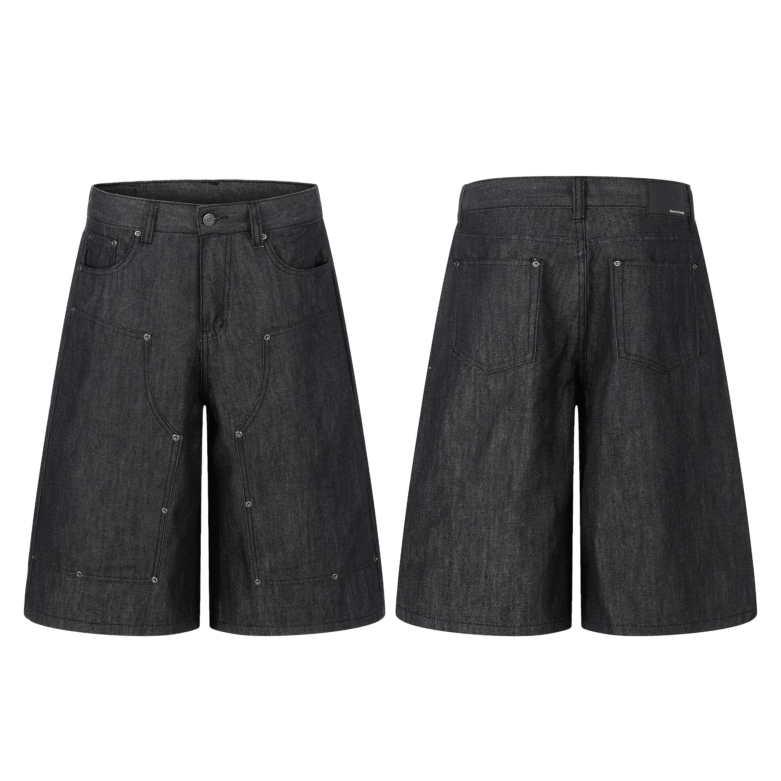 Front and back view of black raw denim baggy shorts with curved panel seams and exposed metal rivets