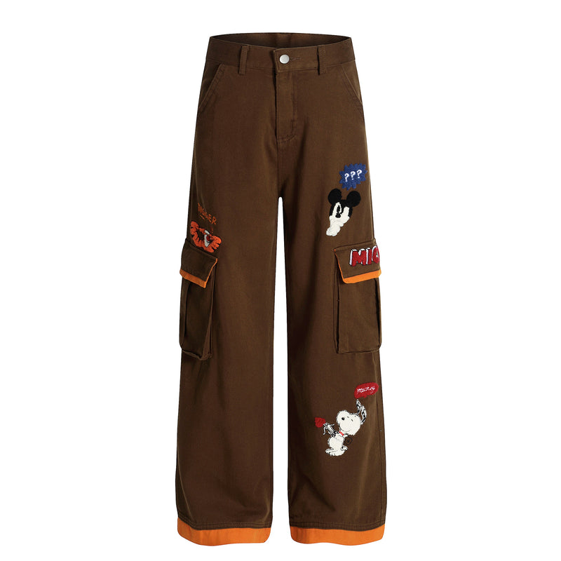Brown wide-leg cargo pants with cartoon patches and orange trim, front view