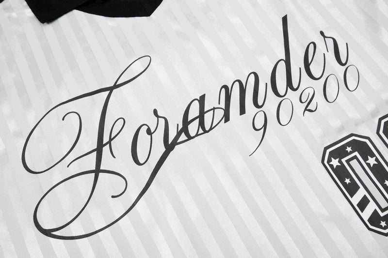Close-up of white striped football jersey with black script lettering and retro-style crest detail