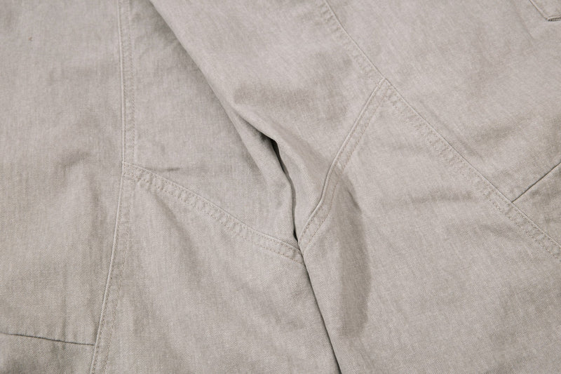 Beige pant leg detail with diagonal seam stitching