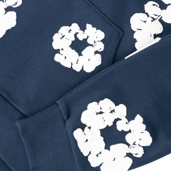 Close-up of the Navy “Cotton Wreath” Denim Tears Hoodie – a streetwear pullover featuring white floral print on the sleeve and body.