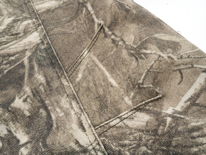 Close-up of camo fabric seam and triangular pocket detail on the pants