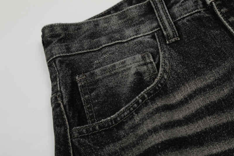 Close-up of front pocket and waist area on black distressed denim pants