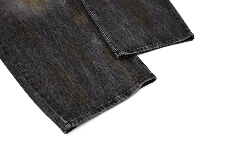 Close-up of hem on black wide-leg denim pants with stitched cuff