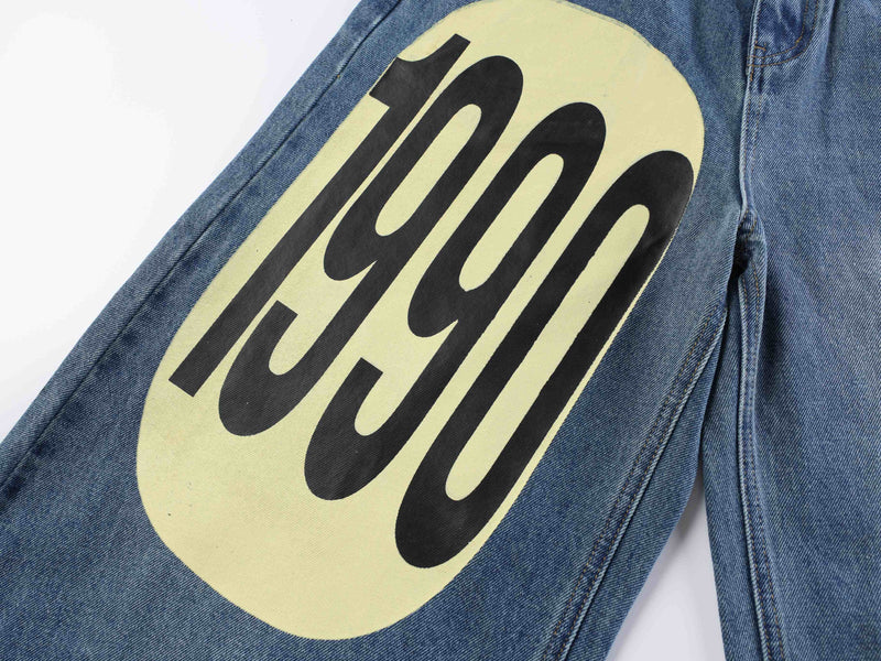Close-up of blue denim leg with large yellow graphic print