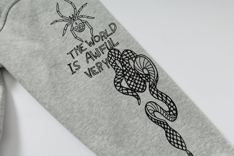 Close-up of sleeve graphic with spider, snake and black doodle text