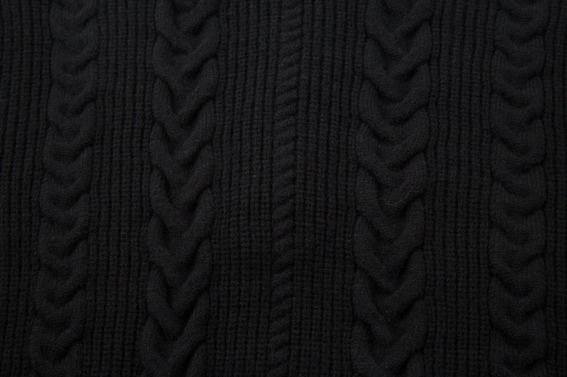 Close-up of black cable knit sweater fabric with vertical ribbed and braided texture
