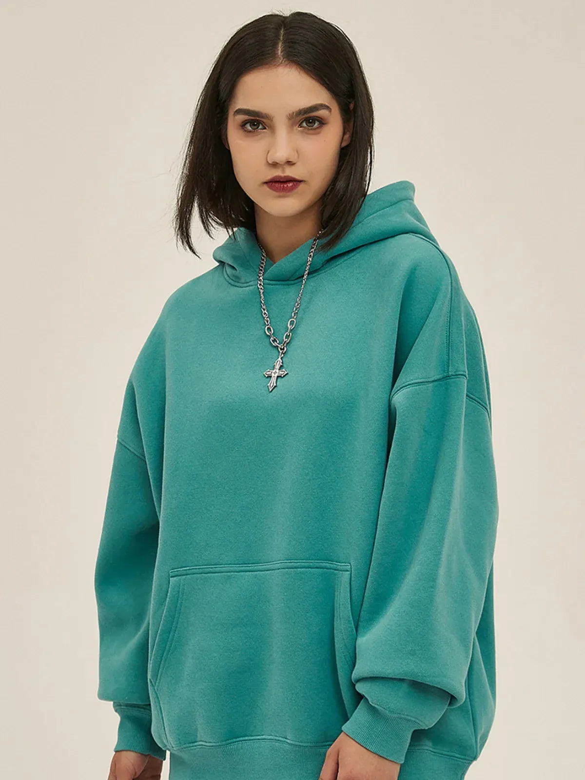 A person with straight dark hair wears the Custom Anime Character Dusty Teal Hoodie—Personalized 350GSM 100% Cotton Pullover—and a silver chain necklace, standing against a plain light background.