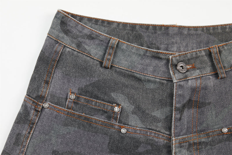 Waistband close-up of gray camo barrel jeans showing angled fly seam and front pocket details