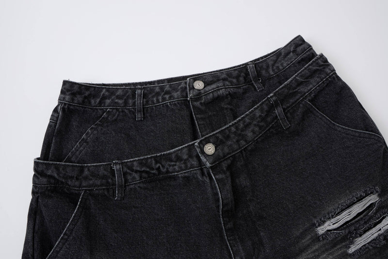 Dark denim shorts with layered waistband, front button details, and ripped leg