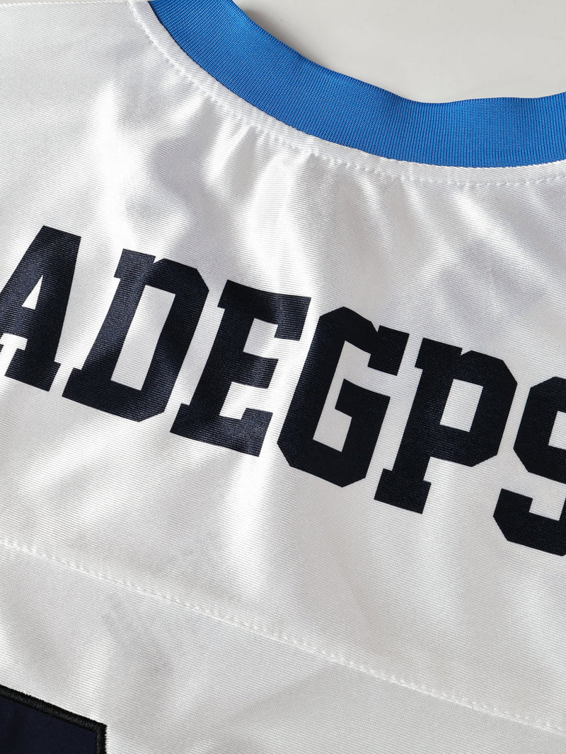White oversized football jersey with blue ribbed collar and bold black MADEGPSR lettering across the chest
