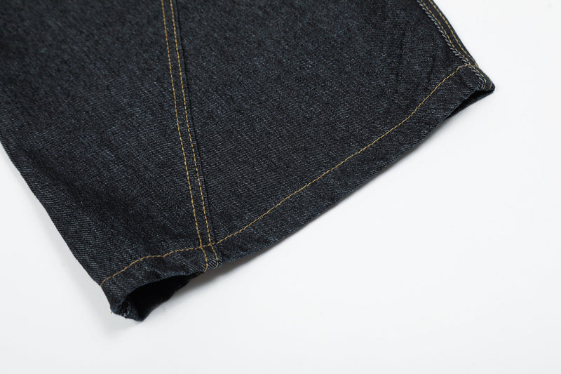 Close-up of black denim hem with contrast topstitching and folded cuff