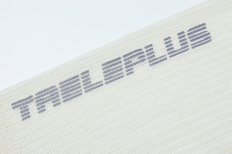 Close-up of sleeve print on cream mesh tee with striped varsity lettering