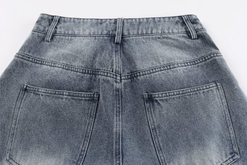 Close-up of the back waistband and pocket stitching on faded denim