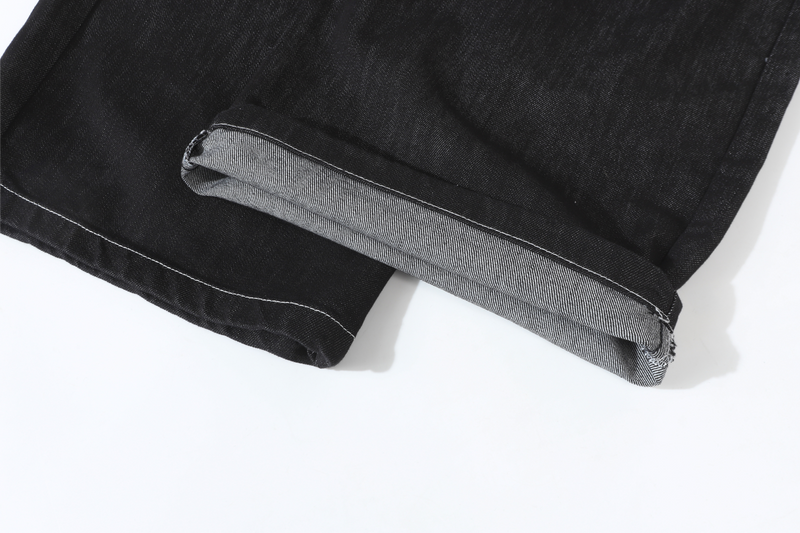 Cuffed hem close-up on black wide-leg denim pants with visible grey inner fold