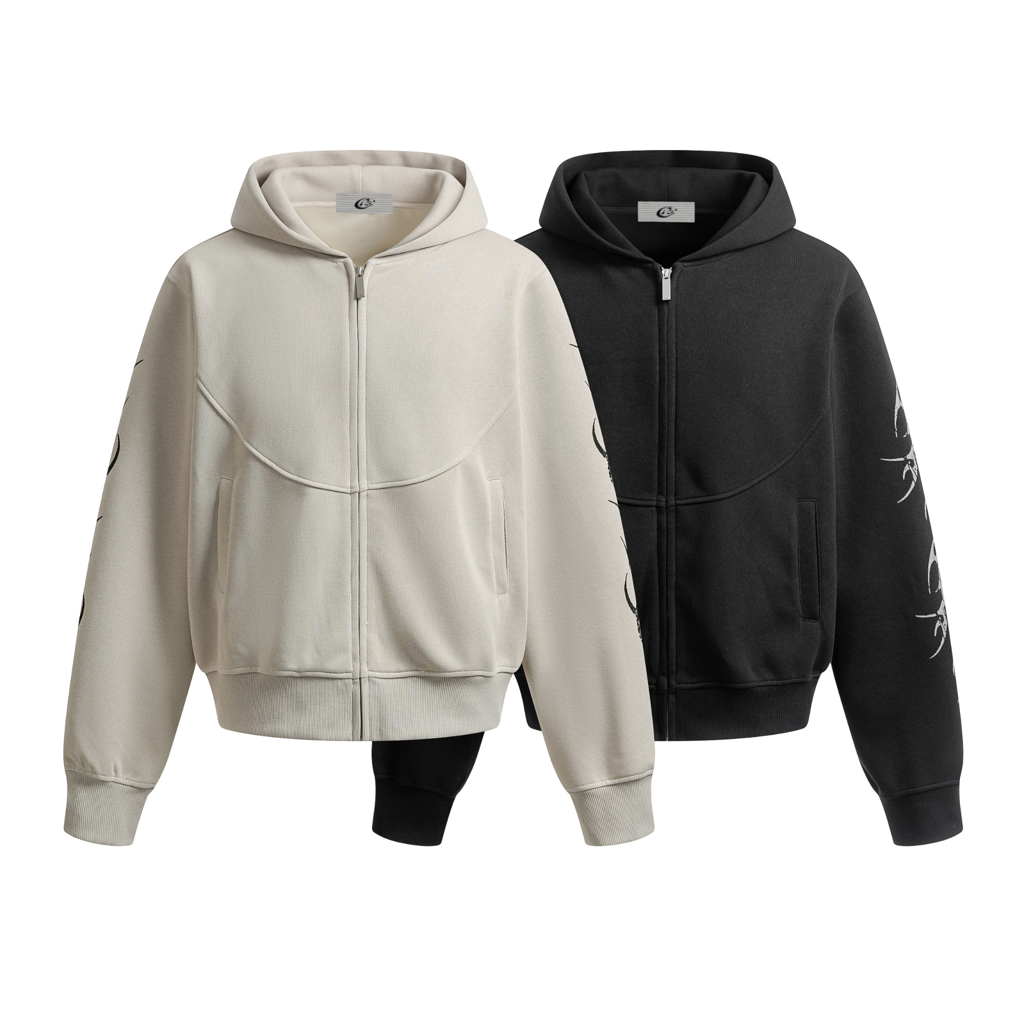 Omirad Tribal Curve Zip Hoodie in cream and black colorways displayed side by side, showing arched chest seam and tribal flam