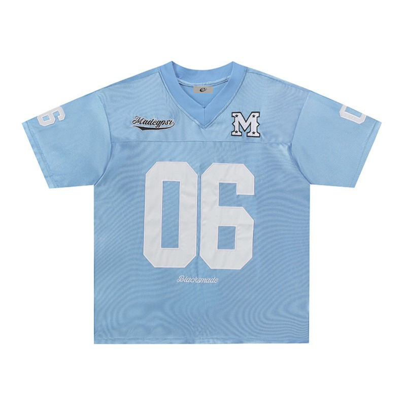 Light blue retro football jersey tee with white number 06, varsity M patch, and streetwear details