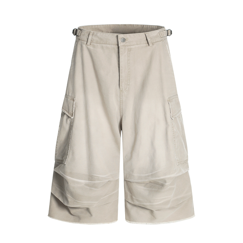 Beige washed cargo shorts front view with wide legs, flap side pockets, and adjustable buckle tabs