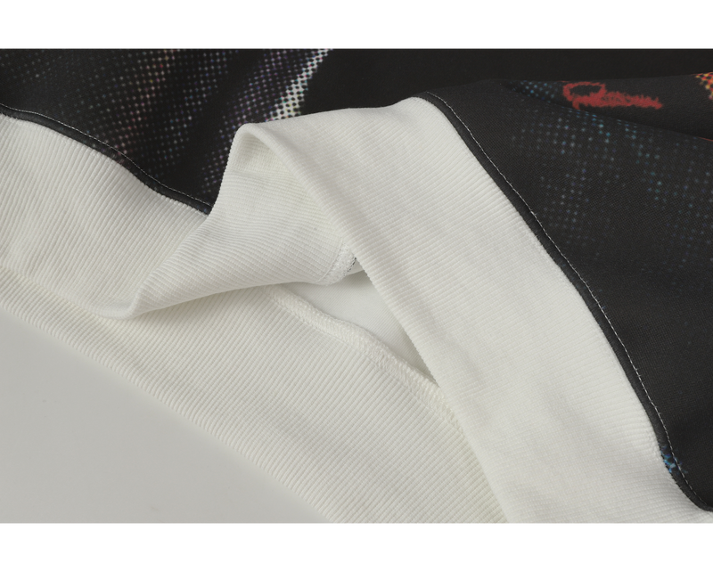 Close-up of hoodie hem seam where the printed black body meets the white ribbed trim