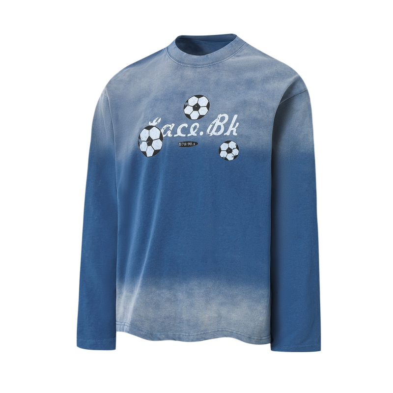 Blue long-sleeve tee front view with centered soccer ball graphics and faded lettering