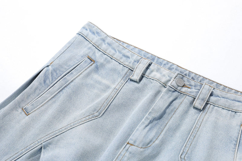 Angled close-up of front waistband and pocket on light wash balloon fit denim jeans