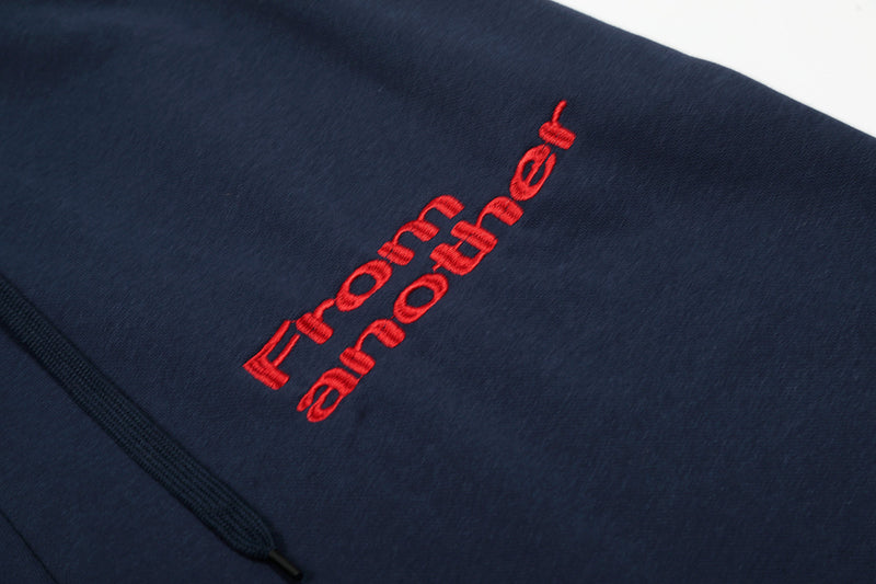 Close-up of red embroidered text on navy shorts