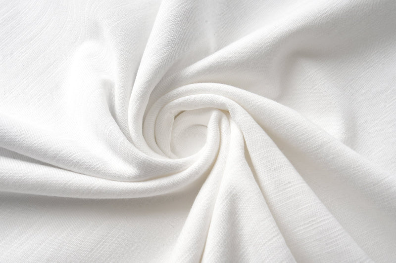 Close-up of soft off-white cotton fabric folded into a swirl