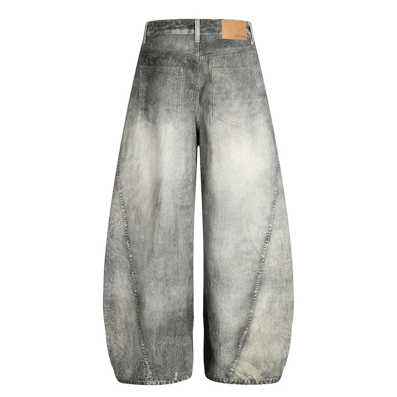 Back view of washed barrel-leg denim pants with rear pockets and tan patch