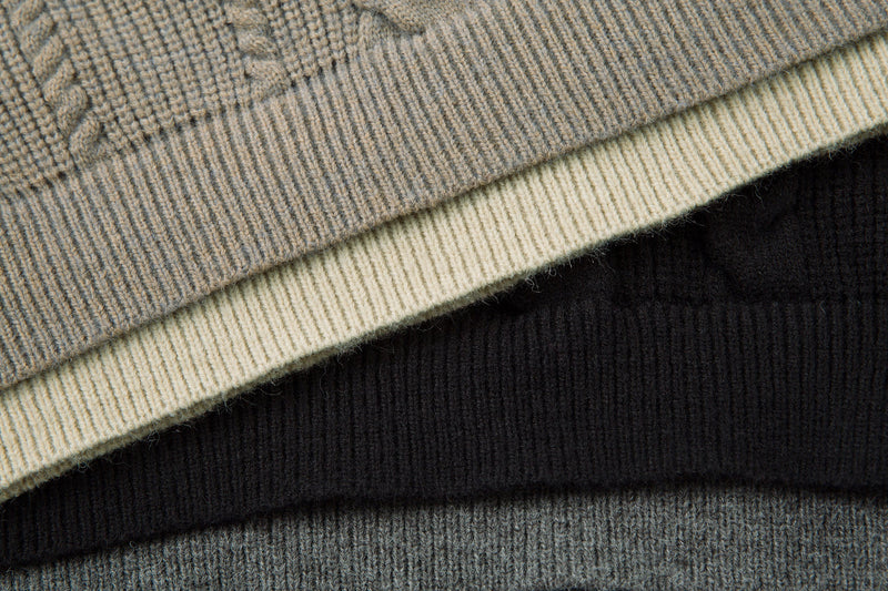 Close-up of beige, cream, and black sweater layers showing contrast collar detail
