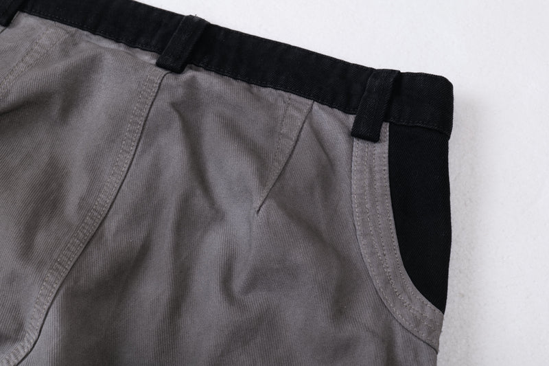 Close-up of the waistband and upper front panel on gray and black cargo pants