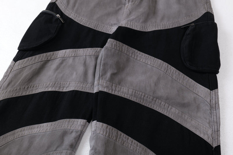 Close-up of the side cargo pockets and curved contrast panels on wide-leg pants