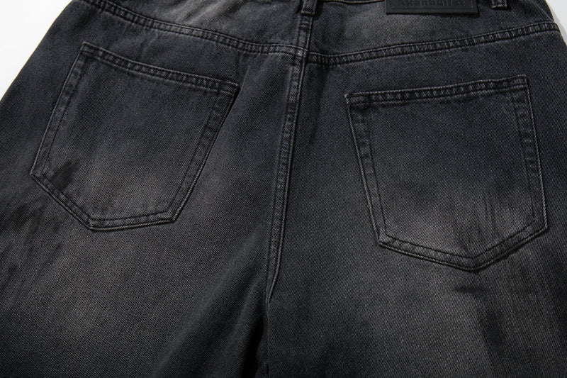 Close-up of back patch pockets on dark wash wide-leg jeans with worn fade detail