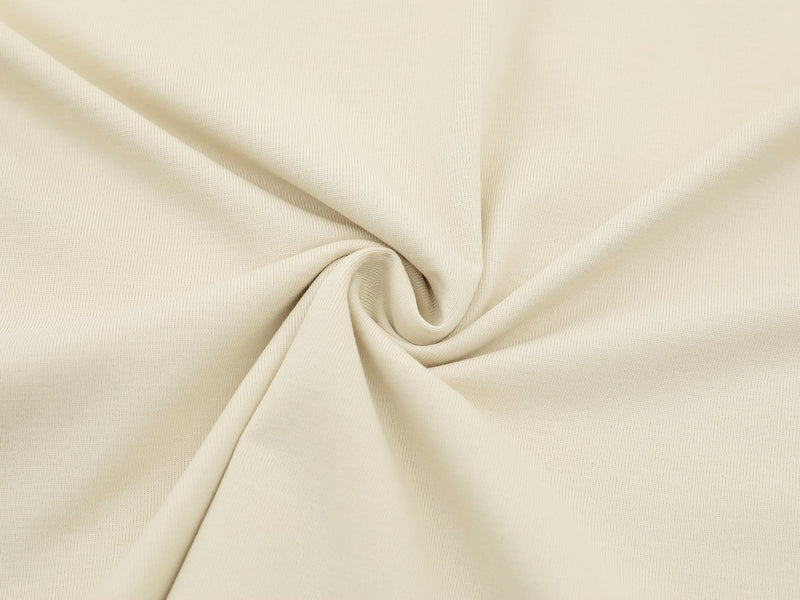 Cream athletic tee fabric close-up with soft draped knit texture and a smooth, lightweight sporty streetwear look
