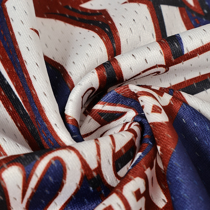Close-up of retro football jersey fabric with bold red, navy, and white varsity lettering and mesh texture