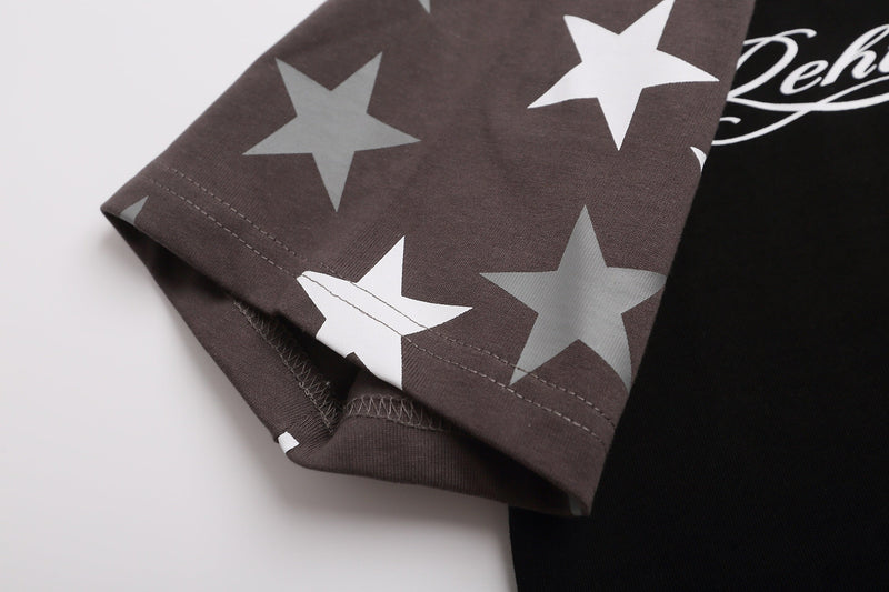 Close-up of a brown raglan tee sleeve with oversized star print and visible hem stitching on black cotton fabric