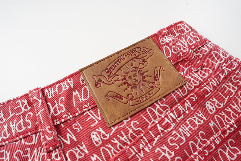 Close-up of tan back patch on red script print pants waistband