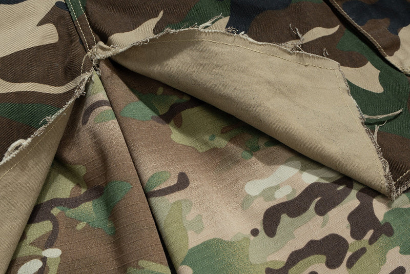 Close-up of patchwork camouflage fabric layers with frayed edges and inner lining