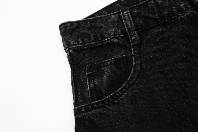 Close-up of the front pocket and waistband on washed black denim pants