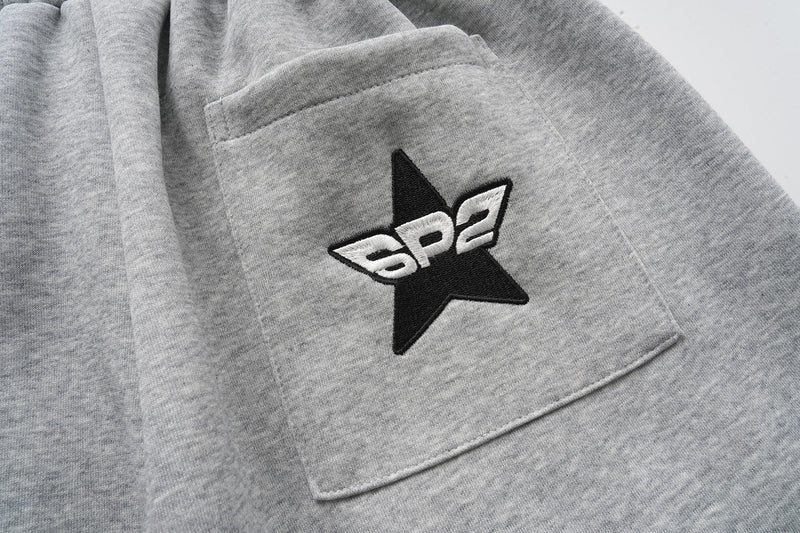 Close-up of back pocket with black star and white SP2 embroidery on gray shorts