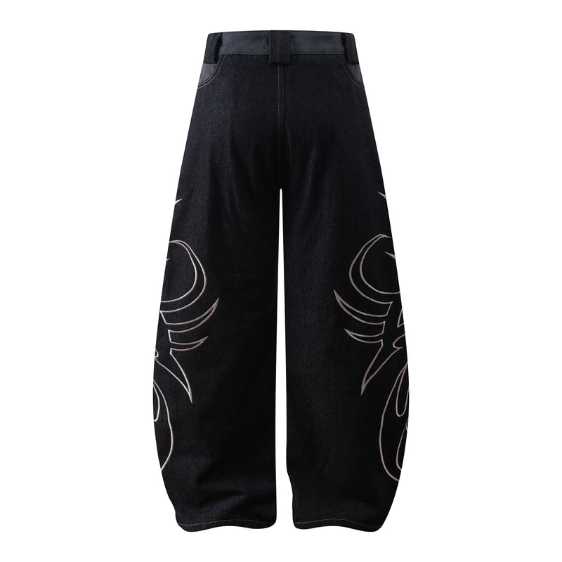 Back view of dark wide-leg jeans with tribal embroidery near the lower legs