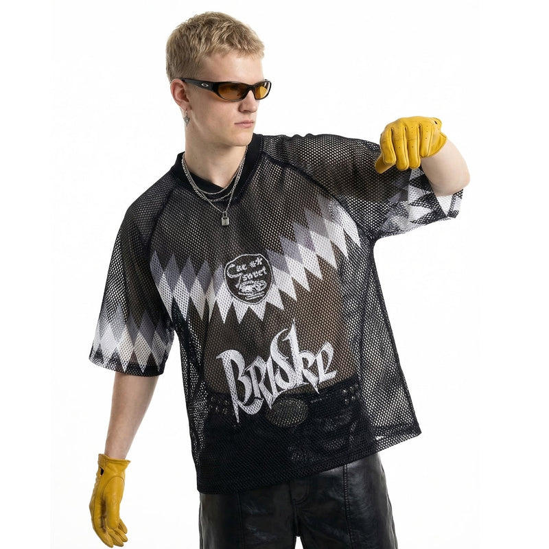 Model wearing black mesh soccer jersey with zigzag graphics, sunglasses, and yellow gloves on a white background