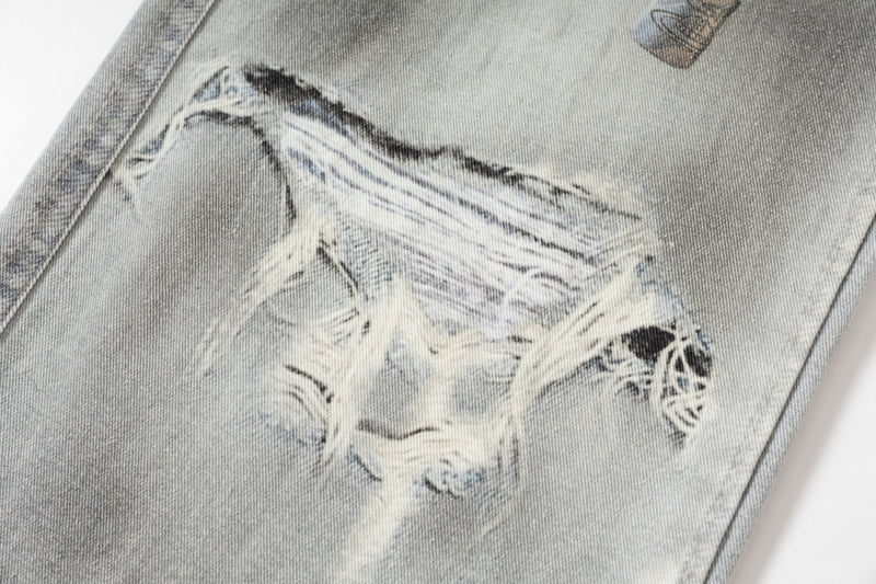 Close-up of distressed ripped knee area on light wash denim