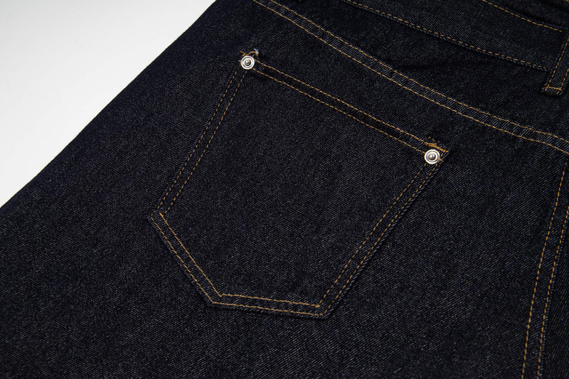 Close-up of back pocket area on dark wash denim shorts with contrast stitching