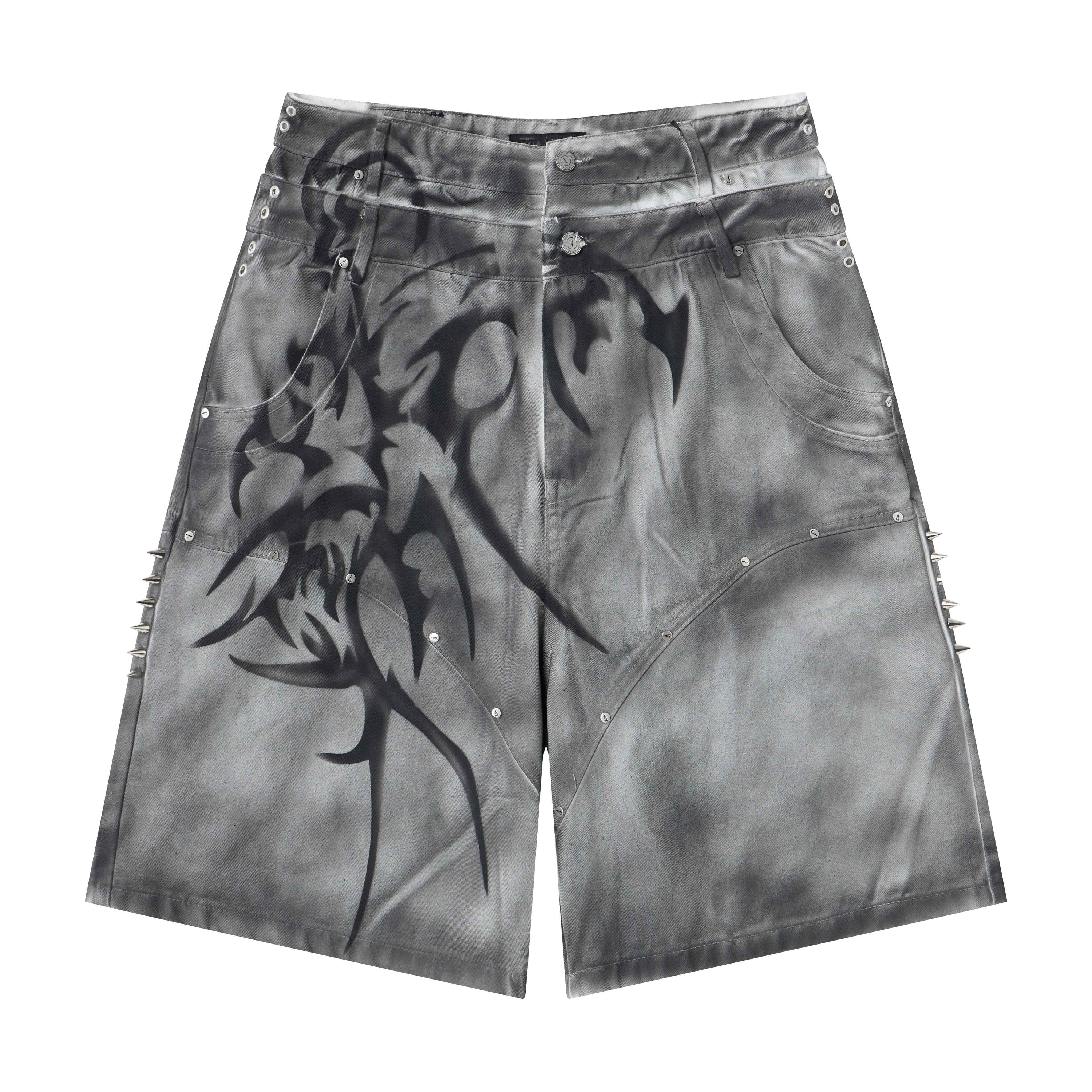 Grey washed wide-leg denim shorts with airbrushed tribal graphics and metal spike side seam accents, front view