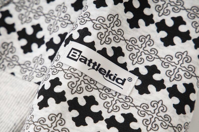 Close-up of fabric label on black and white cross pattern hoodie