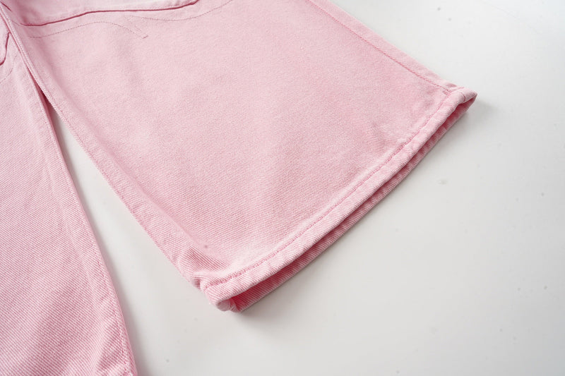 Close-up of wide pink denim hem on washed wide-leg jeans