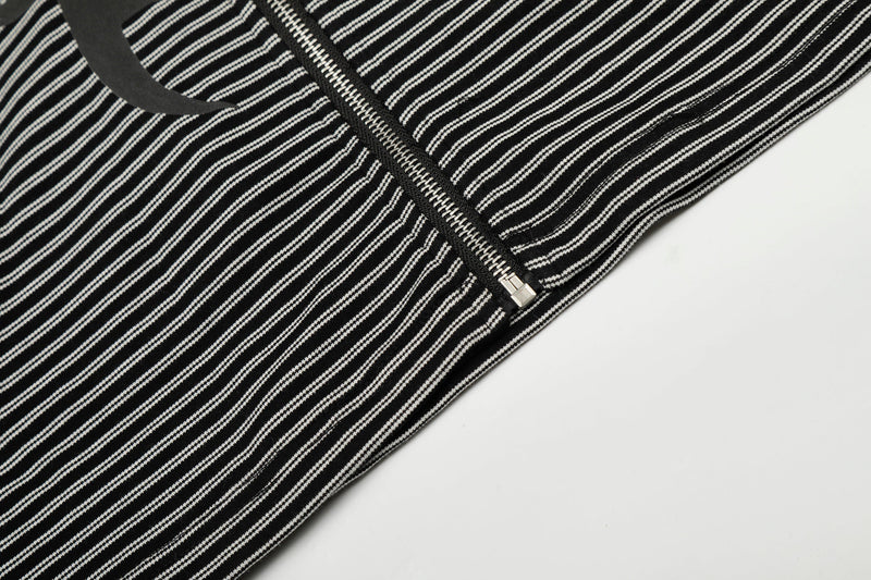 Close-up of lower front hem and zipper on black striped zip hoodie